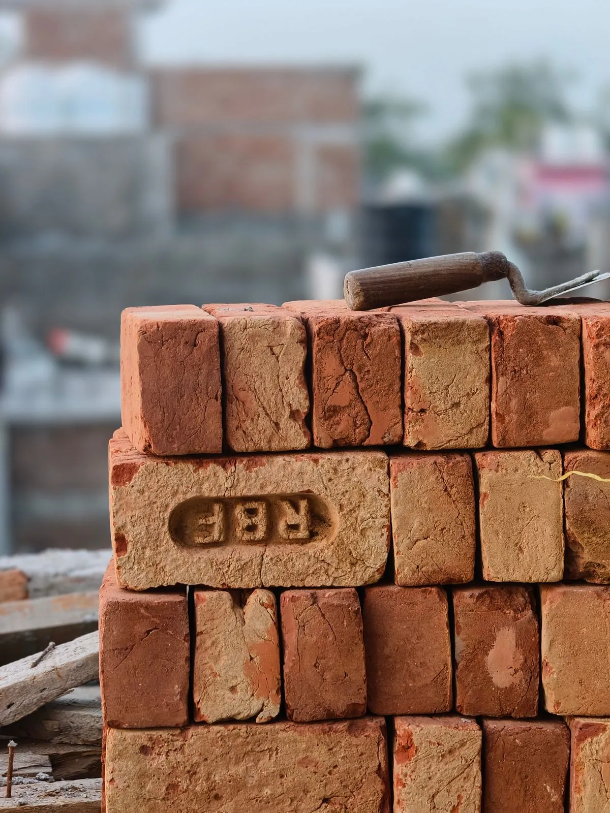 Cegły ceramiczne i kielnia na placu budowy